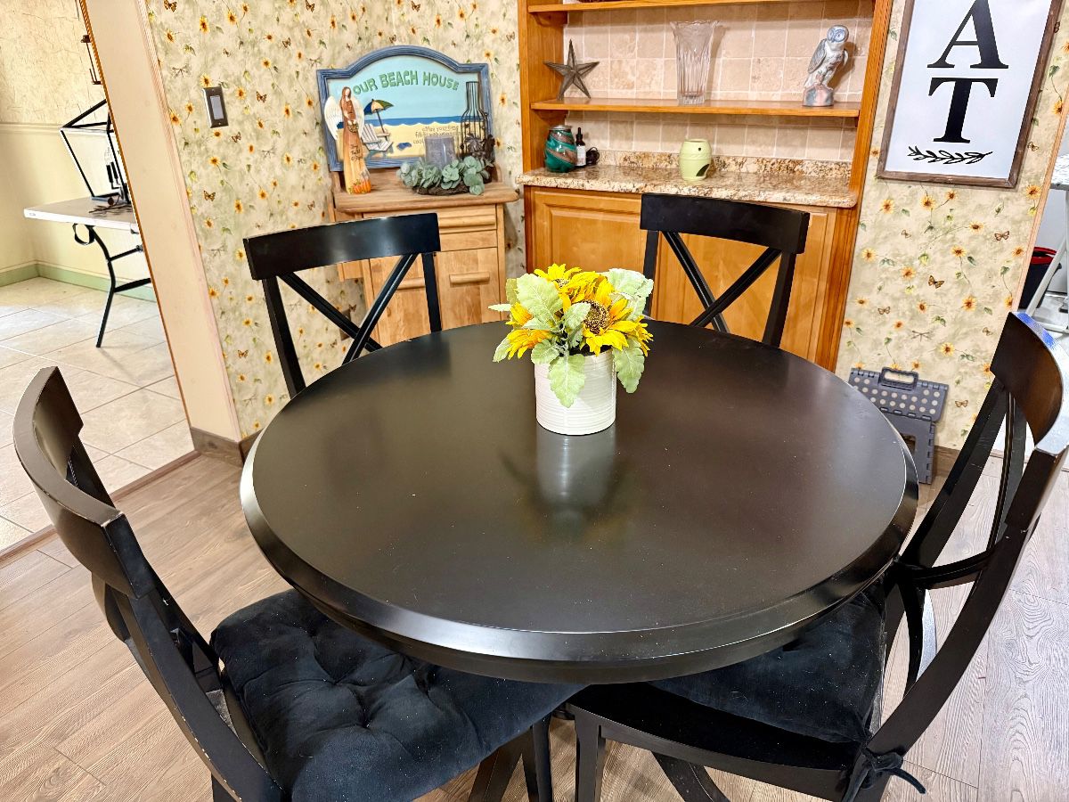 Black Round Dining Table with 4 Chairs and Faux Floral Arrangement
