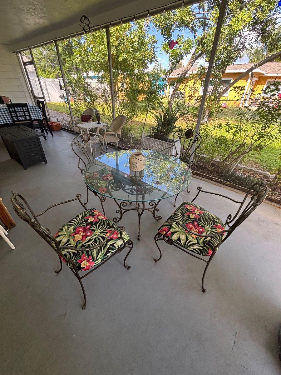 Wrought Iron Glass Top Patio Dining Set with Tropical Floral Cushions