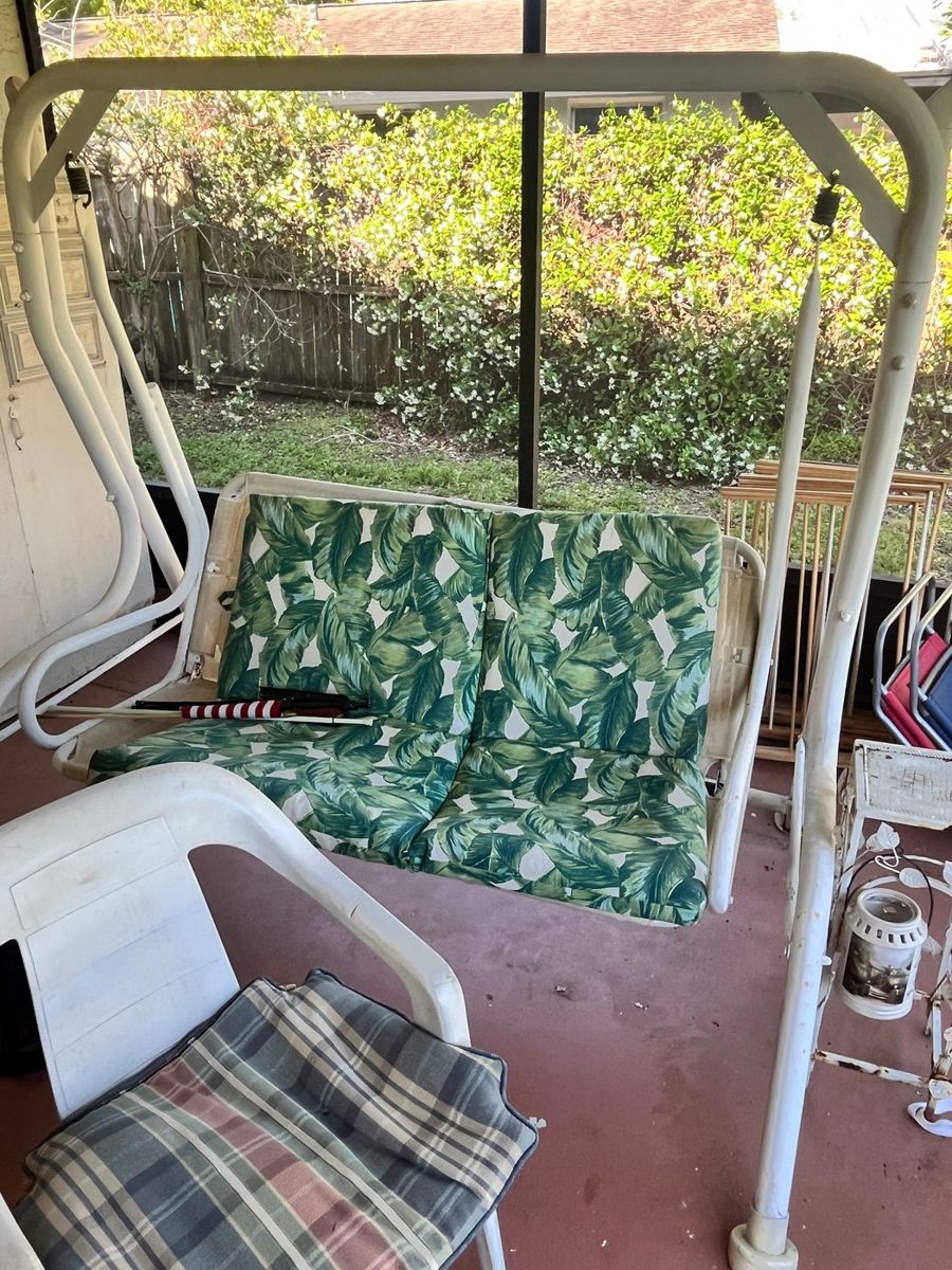 White Metal Porch Swing with Leaf Pattern Cushions
