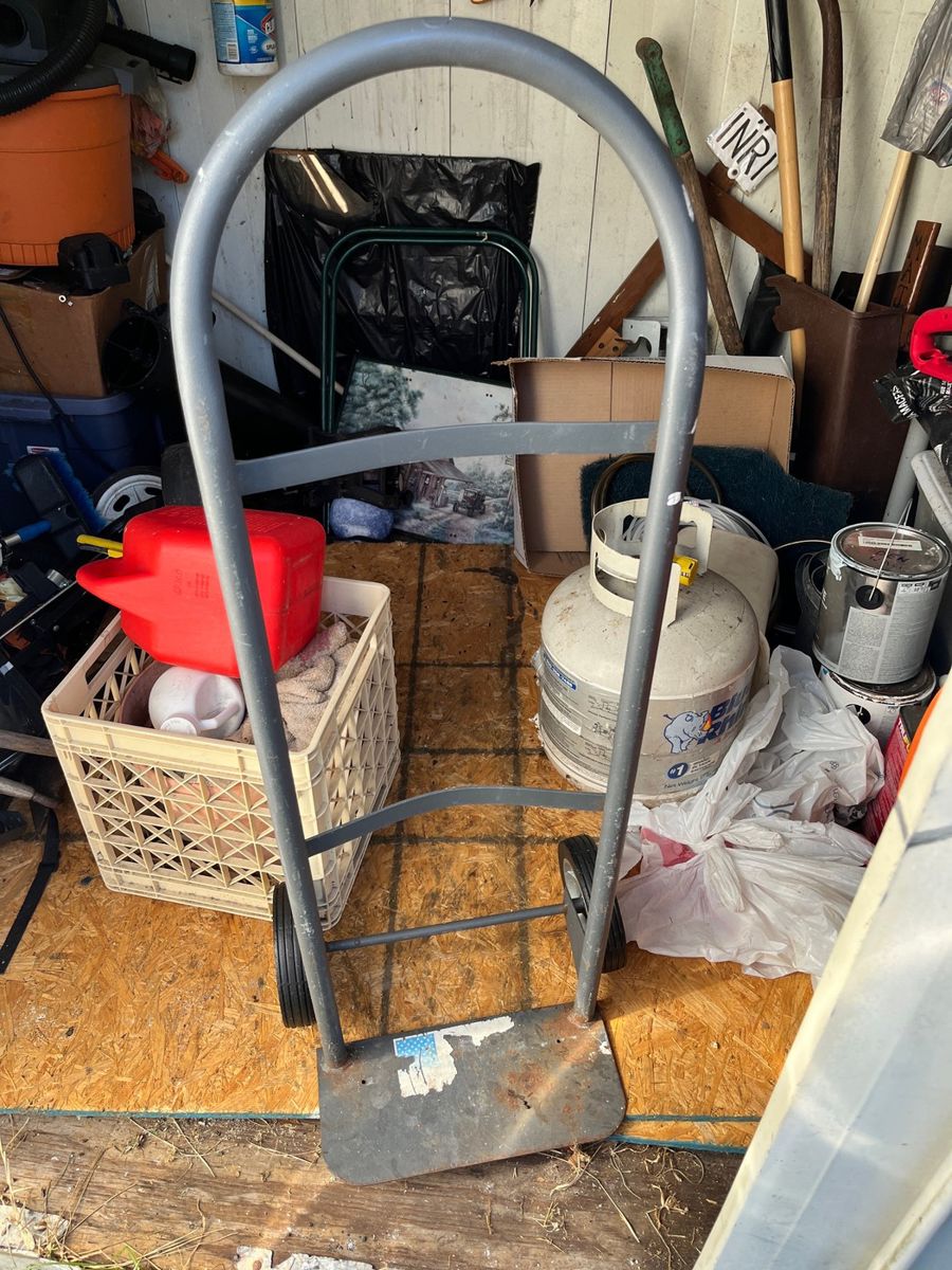 Garage & Shed Assortment: Hand Truck, Propane Tank, Garden Supplies, and Storage Containers